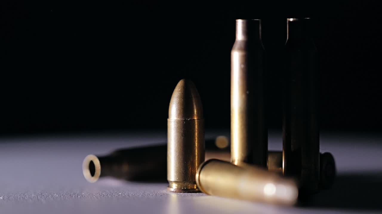 Close up of bullet and shells turning slowly on metallic base in NATO region