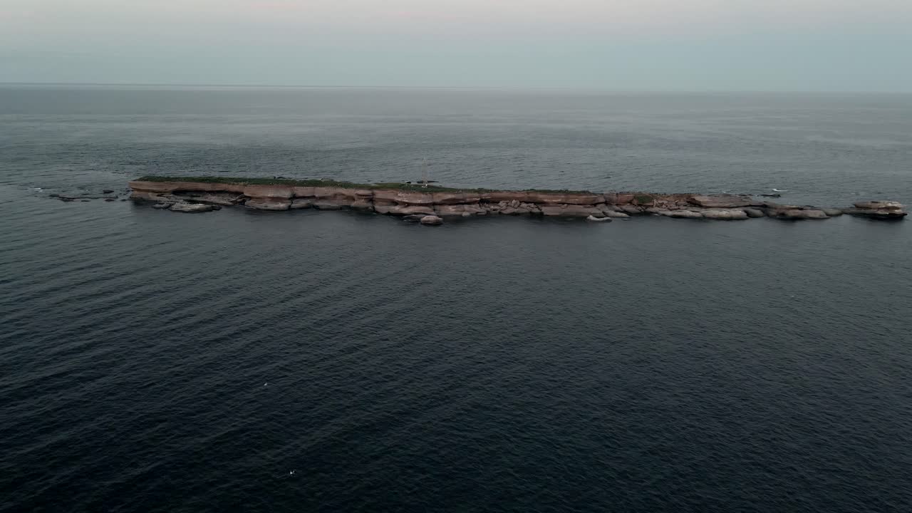 일출에 평평한 섬을 날아가는 것 - 캐나다 퀘벡의 포인트 생 피에르 근처의 세인트 로렌스 만 옆에 있는 일판