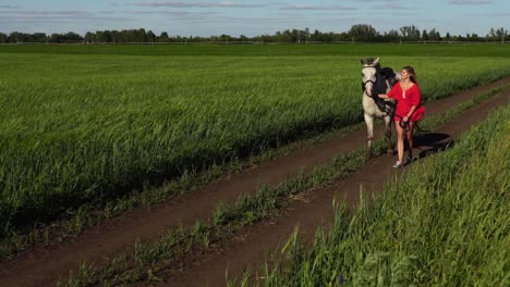 woman walking horse in countryside field