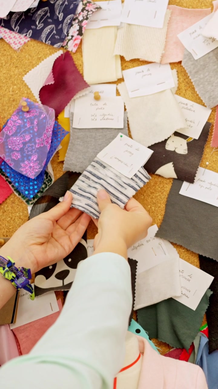 Diseñador de moda eligiendo muestras de tela en un moodboard