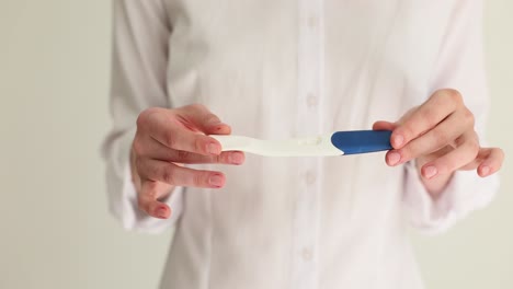 woman holds a pregnancy test, showing a negative result