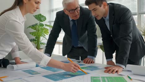 Professional Architects and Engineers Reviewing Blueprints During a Meeting