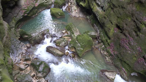 vista superior en cámara súper lenta de salpicaduras de agua en el cañón entre rocas durante el día soleado - prores422