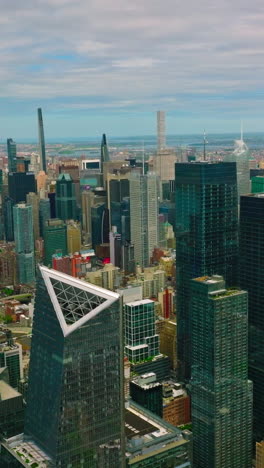 stunning view of the modern architecture of new york. mirror skyscrapers towering over the city. cloudy blue sky backdrop. vertical video