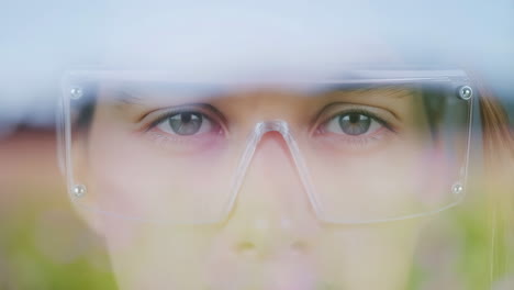 close-up of a person's eyes behind clear safety glasses