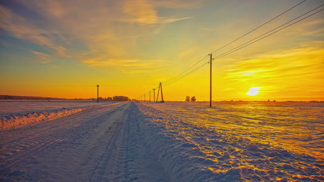 Toma-De-Lapso-De-Tiempo-De-La-Hermosa-Puesta-De-Sol-Naranja-En-El-Horizonte-Del-Camino-Rural-Nevado-Y-El-Paisaje