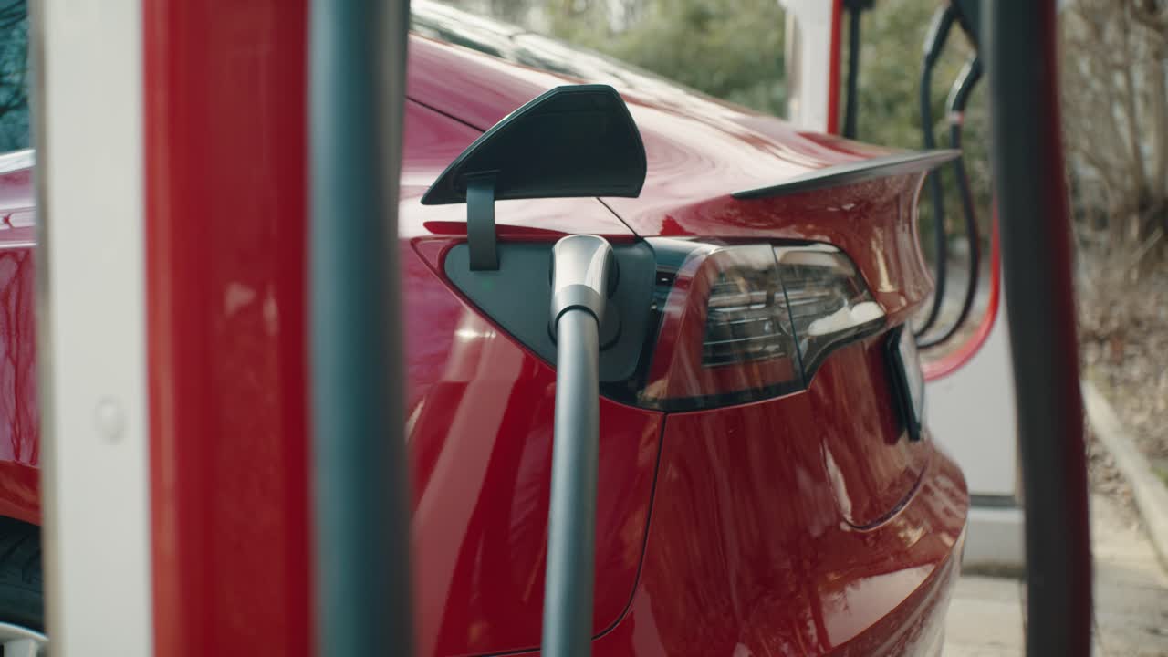 Red electric car is being charged