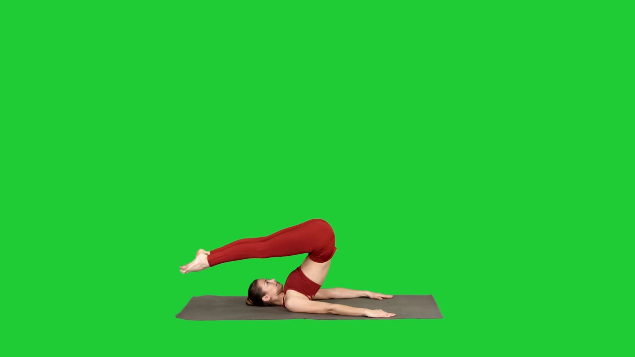 Sportliche junge Frau macht Yoga-Übungen für Bauchmuskelkraft, Unterstützter Schulterstand Asana, Salamba Sarvangasana auf einem Green Screen, Chroma Key