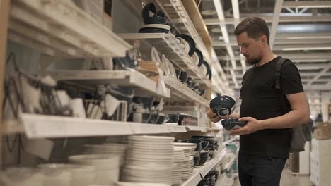 man shopping for dishes in a store