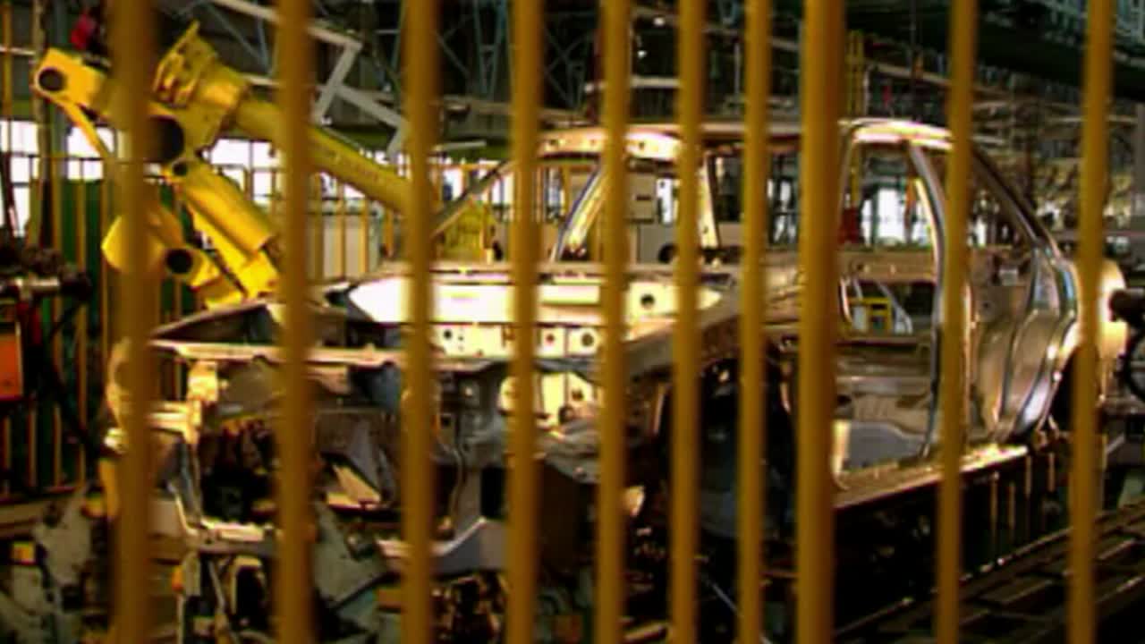 Industrial robotic process of manufacturing of cars in a factory