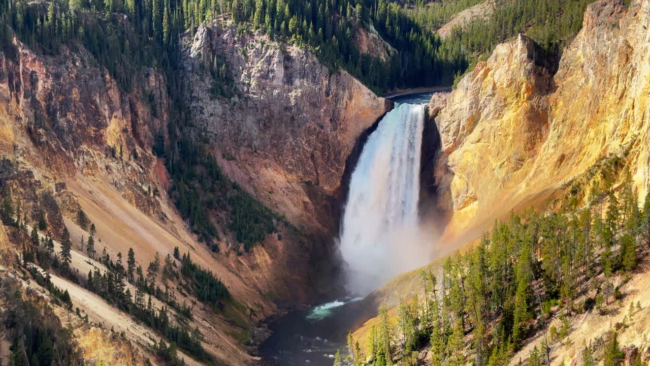 Air Terjun Grand Canyon Taman Nasional Yellowstone. Sungai, Air Terjun Atas, Air Terjun Bawah. Titik Pandang HDR, Artist Point. Musim gugur. Pemandangan lanskap siang hari yang menakjubkan di sekitar Pondok Canyon Village dan jalan raya. Rekaman sinematik pan-up perlahan.