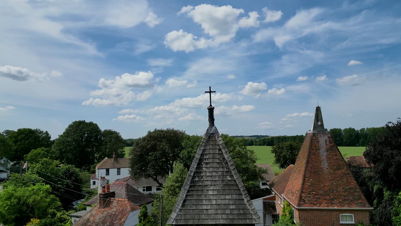 A rising pedestal shot of St Mary's church tower, rising above to show the fields in the background