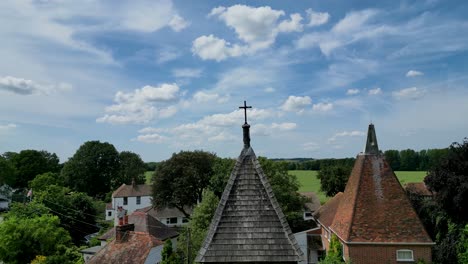 A-rising-pedestal-shot-of-St-Mary's-church-tower,-rising-above-to-show-the-fields-in-the-background