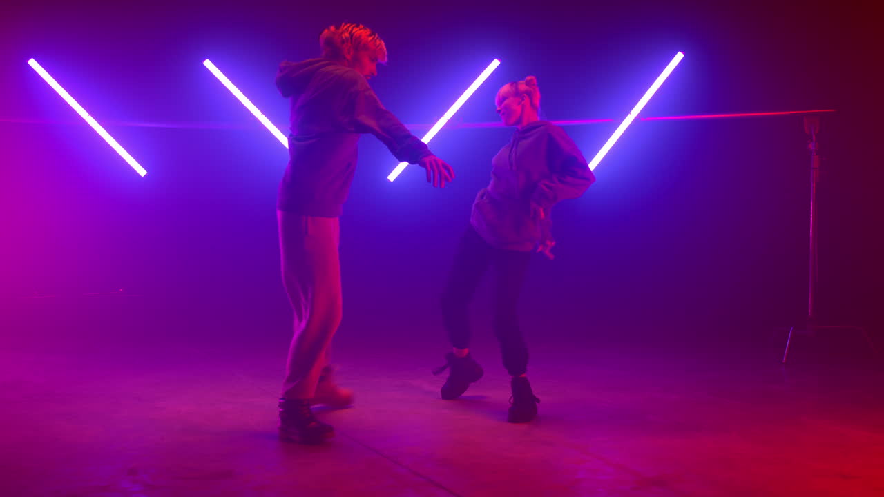 una pareja de artistas haciendo un espectáculo de hip hop en el club. dos estilos modernos de baile callejero.