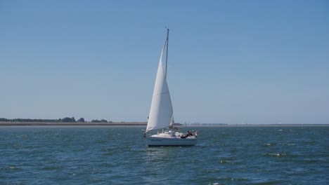 Ein-Weißes-Segelboot,-Das-An-Einem-Sommertag-Am-Nachmittag-In-Zeitlupe-Auf-Dem-Meer-Segelt