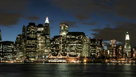 Panorámica-Lenta-De-Una-Foto-Secuencial-De-Nubes-En-Tonos-Rosa-Y-Morado-Que-Pasan-Sobre-El-Horizonte-De-La-Ciudad-De-Nueva-York-Mientras-La-Hora-Dorada-Cambia-A-La-Noche