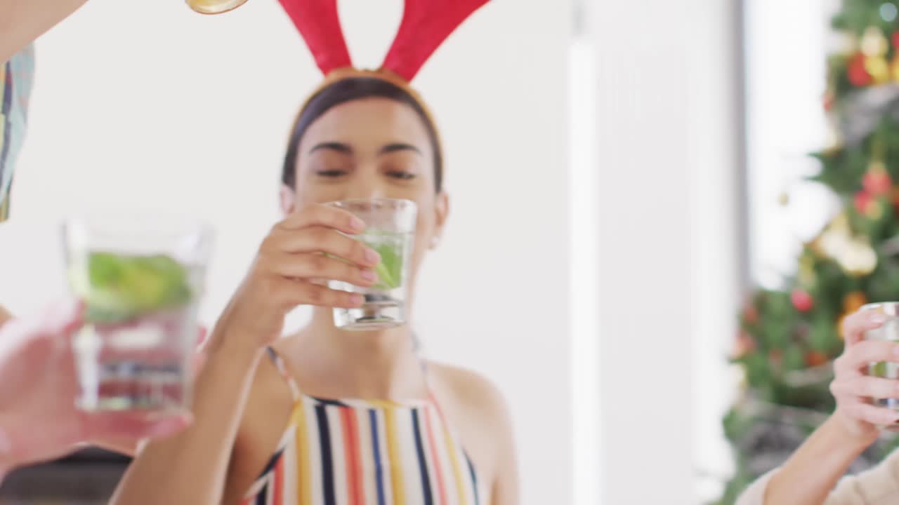 un grupo feliz de amigos diversos sentados a la mesa y cenando juntos, haciendo tostadas