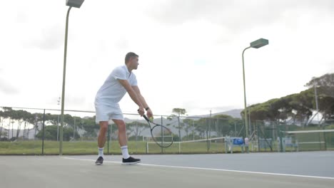 Tenista-Caucásico-Sirviendo-Pelota-En-Una-Cancha-De-Tenis-Al-Aire-Libre-En-Cámara-Lenta