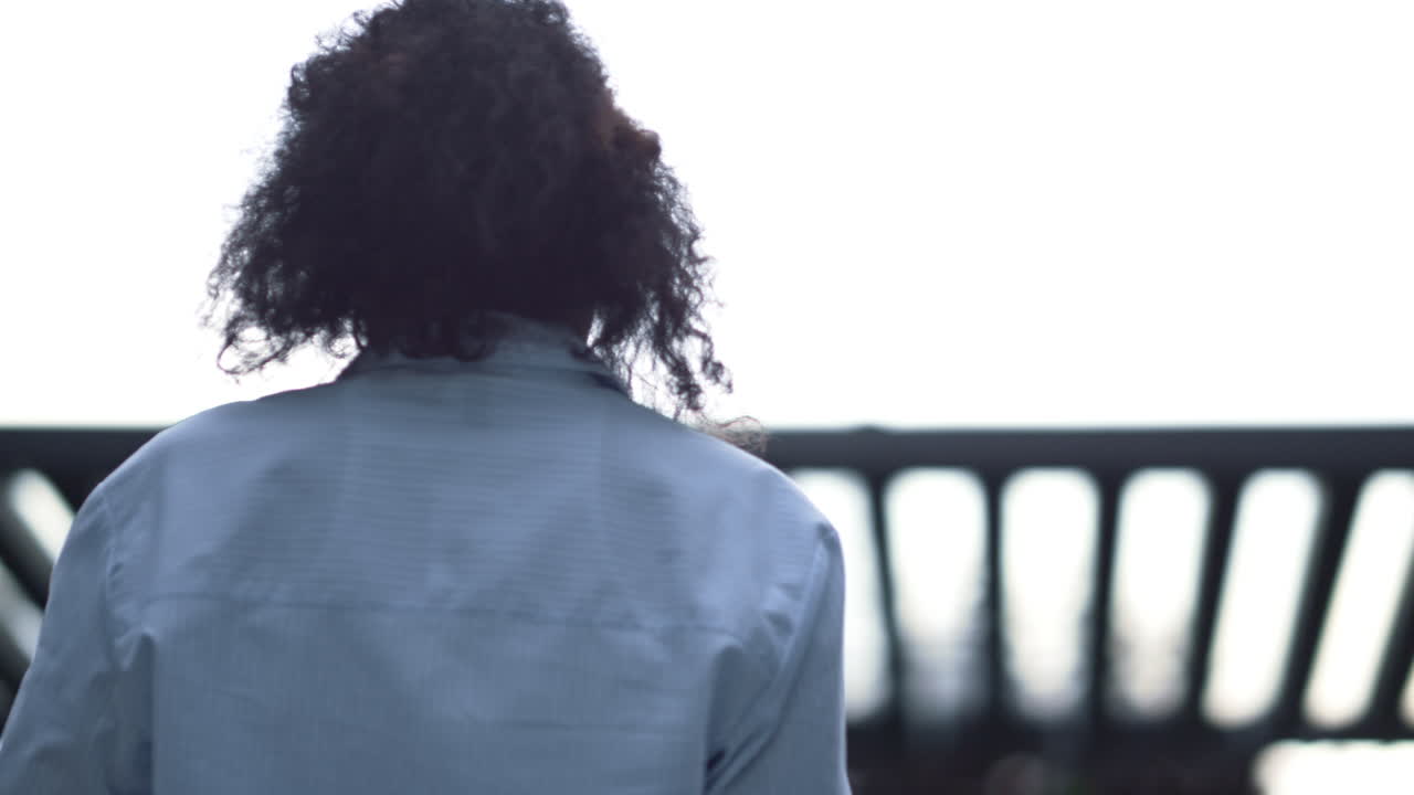 mujer sonriente trabajando en una tableta fuera de un moderno edificio de oficinas en primer plano.