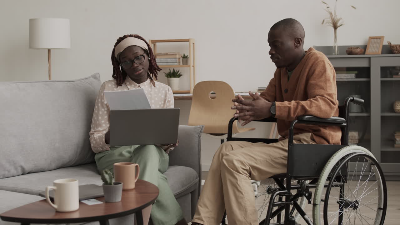 African-American Woman Helping Handicapped Man with Paperwork