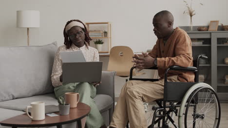 african-american woman helping handicapped man with paperwork