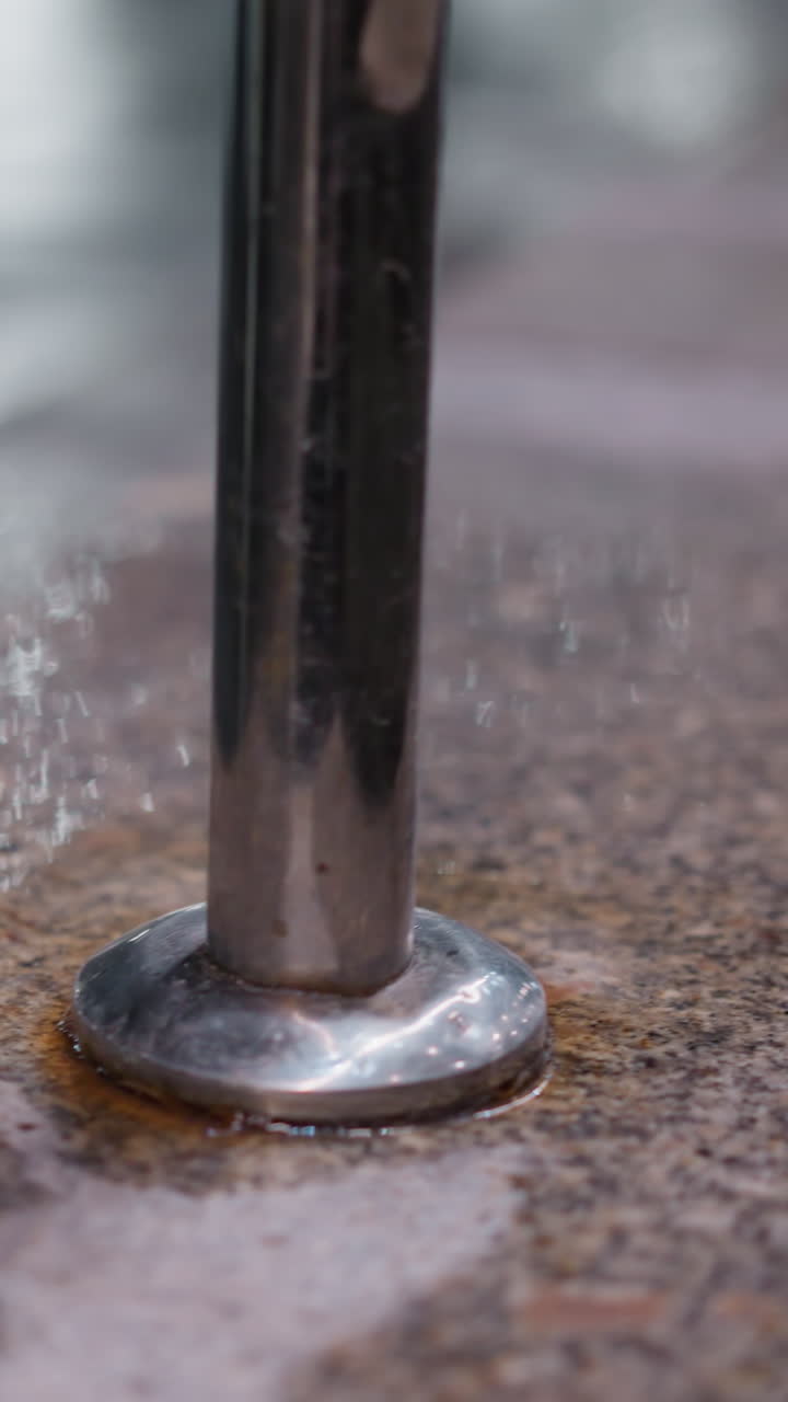 돌로 된 계단에 있는 금속 드레일의 근사한 모습, 재료의 질감을 강조하는, 부드럽고 반사적인 금속은 거칠고 날씨가 은 것과 대조된다.