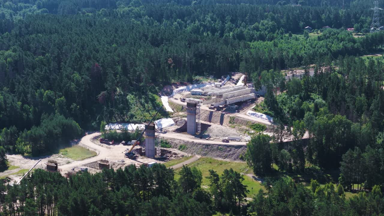 Rail Baltica railway bridge columns surrounded with dense woodland, aerial view