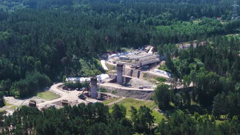 rail baltica railway bridge columns surrounded with dense woodland, aerial view