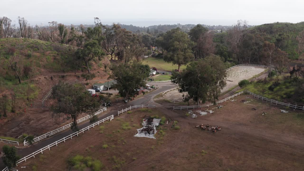 Low aerial shot flying over Jigsaw Farms towards the burned down ranch house at Will Rogers State Historic Park after the fire in Pacific Palisades, California. 4K
