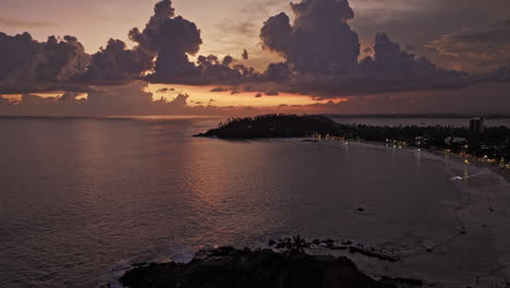 Mirissa-Sri-Lanka-Antena-V15-Drone-Cinematográfico-Bahía-De-Paso-Elevado-Inverso-Que-Captura-El-Paisaje-Prístino-De-La-Roca-Loro-Y-La-Playa-Costera-Con-Una-Hermosa-Puesta-De-Sol-En-El-Océano-Índico---Filmada-Con-Cine-Mavic-3---Abril-De-2023