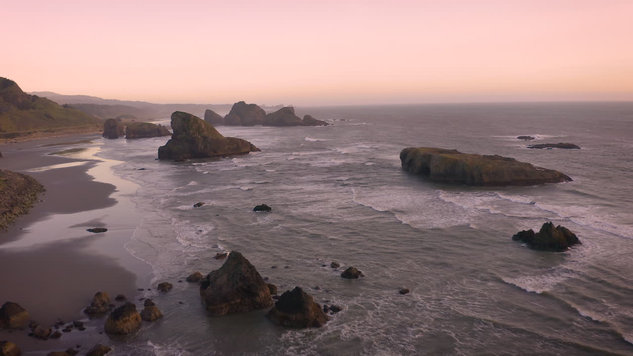 antena de pilas de mar en la costa sur de oregón durante una puesta de sol rosa malhumorada