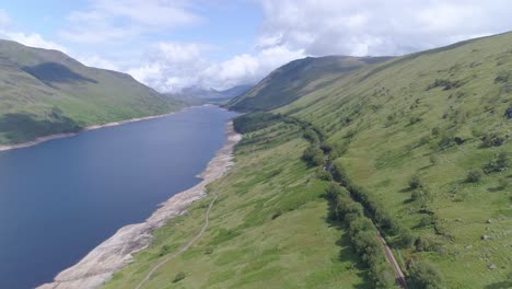 High-aerial-shot-above-the-train-line-along-the-shore-of-Loch-Treig,-Rannoch-Moor