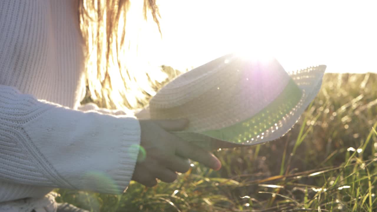 Woman waving straw hat in the sunshine medium shot