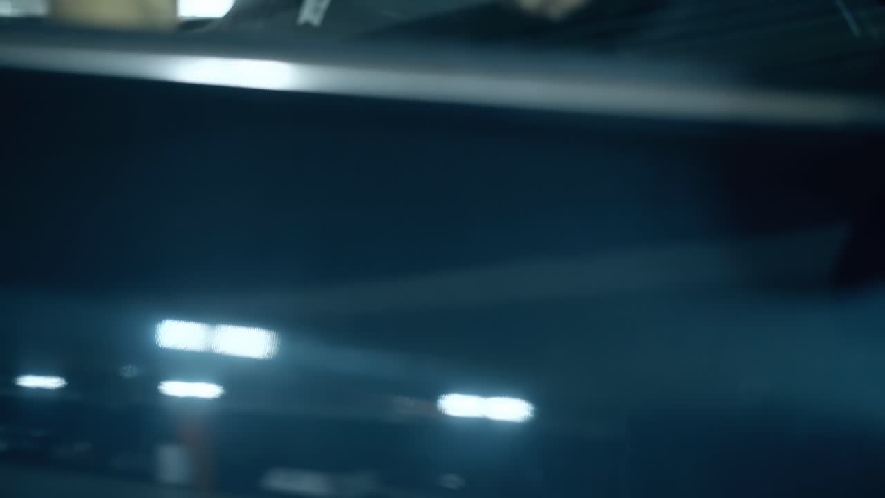 hombre de vista cercana abre la puerta del coche negro entra en el estacionamiento