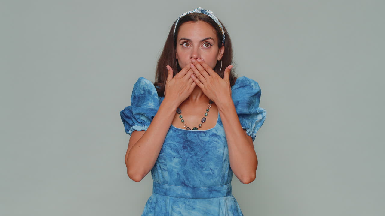 una mujer asustada cerrando la boca con la mano negándose a contar un secreto terrible, una verdad increíble