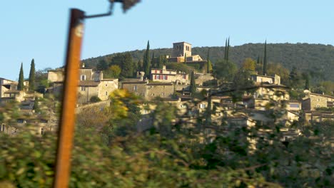 old typical provencal country village under sunny skies in slowmotion moving shot through nature