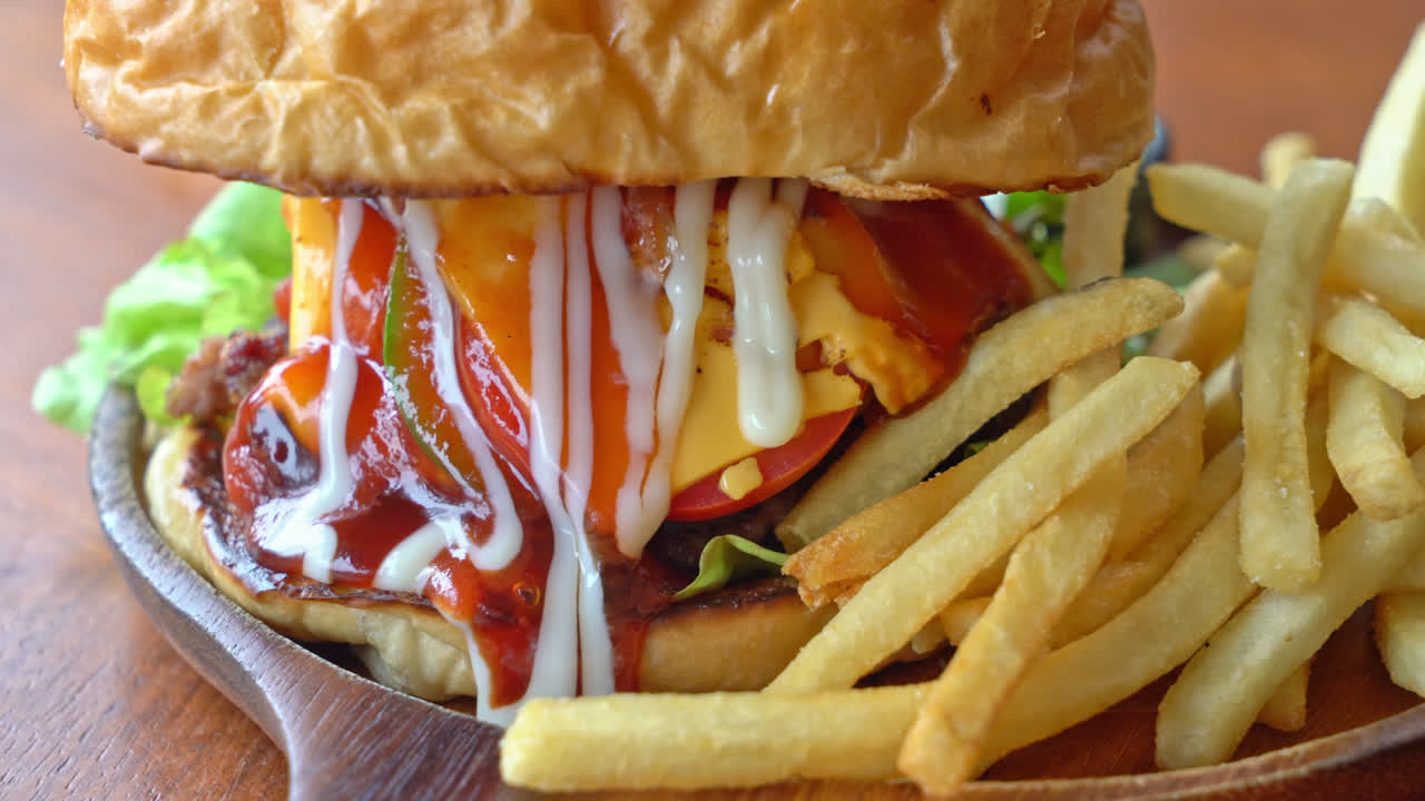 치즈와 나무 접시에 소스와 함께 쇠고기 햄버거