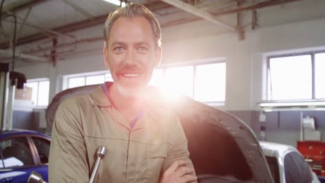 mechanic standing in repair shop with wheel brace