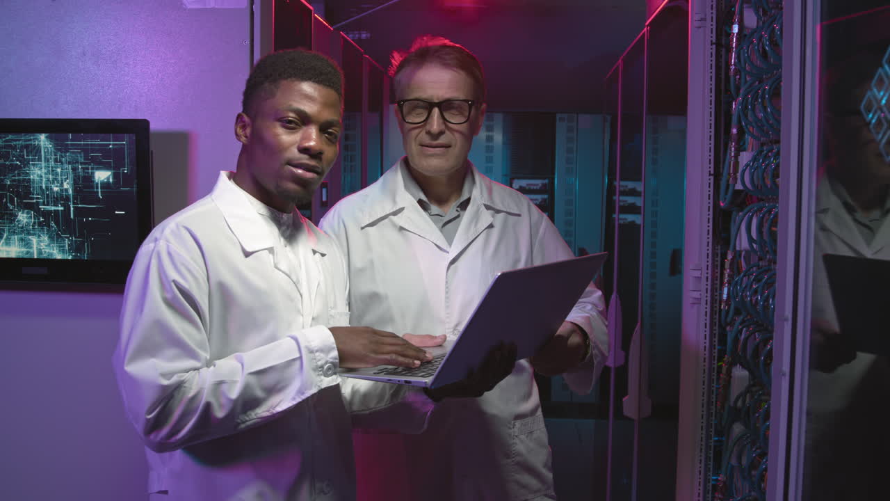 Technicians in Lab Coats Working in Data Center