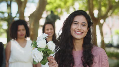 portrait of smiling bridesmaid looking at camera with bridal bouquet