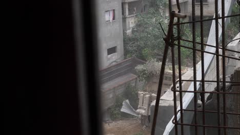 War-scene-in-Gaza-Strip,-hidden-among-rubble-as-a-military-vehicle-passes-by