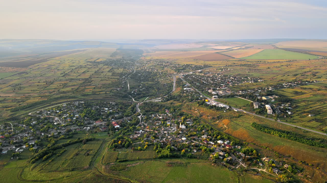 Aerial drone view of village in Moldova. Residential buildings, greenery, fields around