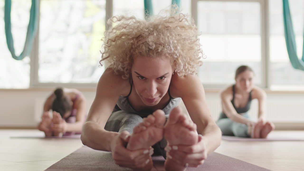 Blonde Woman Stretching in Yoga Class