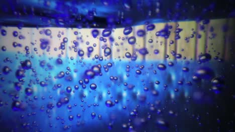 vista ampliada de las burbujas de aire dentro de una botella grande de desinfectante de manos ya que el fondo es colorido y cambiante