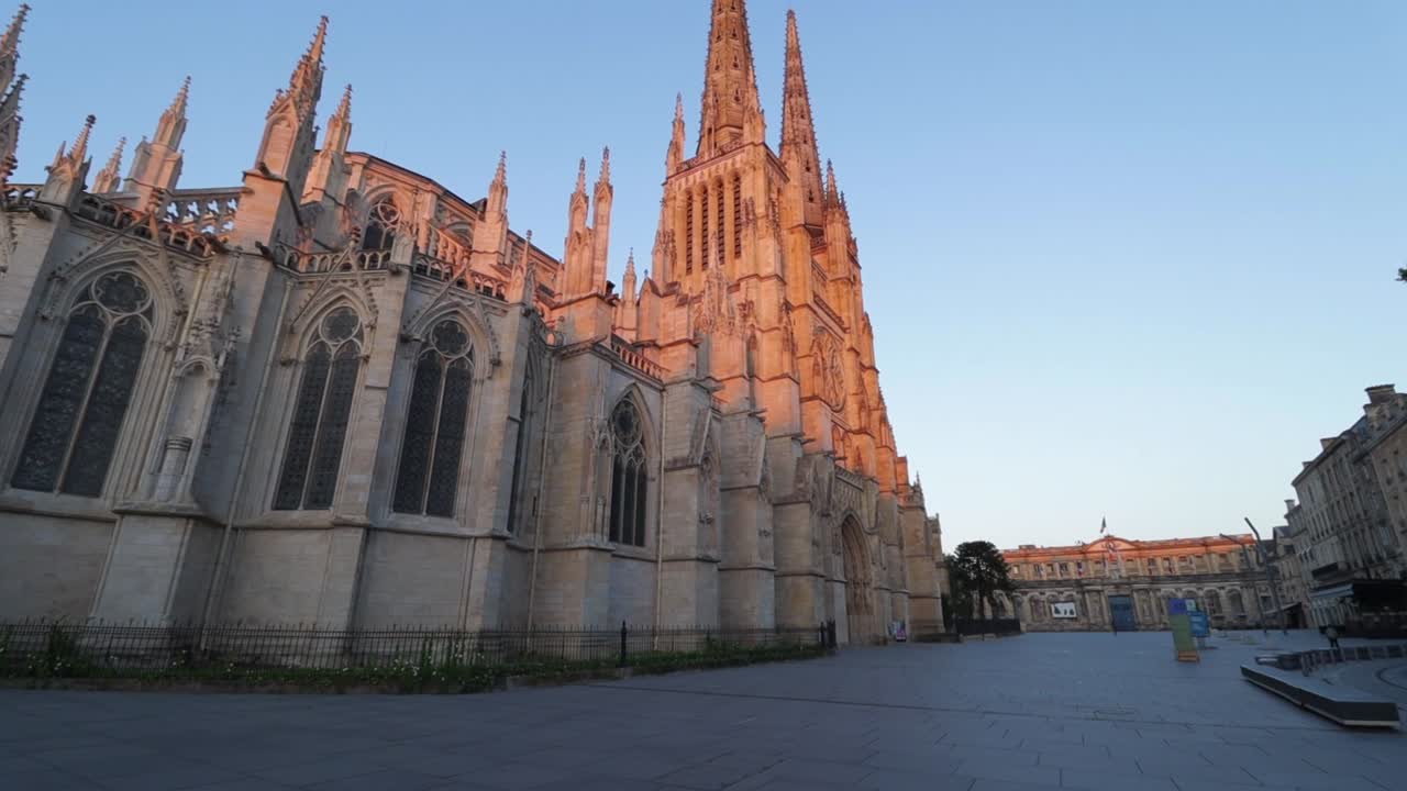 Saint andrew cathedral side wall and pey berland square empty during sunrise with nobody, moving smooth wide shot