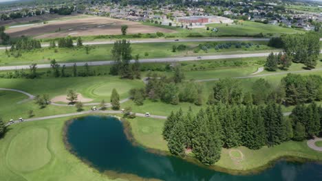 drone view of golf course green, fairway and water hazard