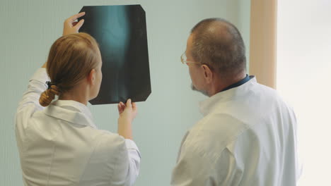 male and female doctors examining x-ray images