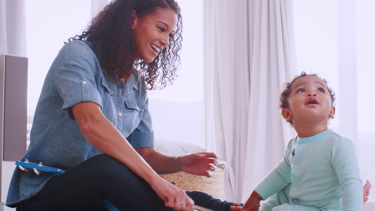 joven madre negra tocando el xilófono con su hijo pequeño