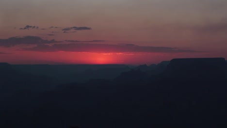 bright red sunset disappearing behind a dark nighttime grand canyon, arizona