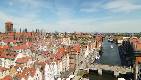 People-Walking-At-Green-Bridge-Across-Motlawa-River-In-Gdansk-Old-Town,-Poland-With-View-Of-St